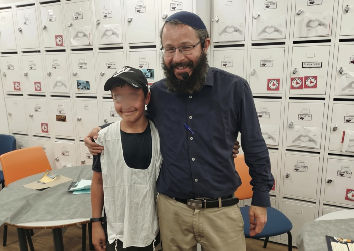 קושרים ונקשרים - תלמיד מקבל ברכה בסיום הקשירה